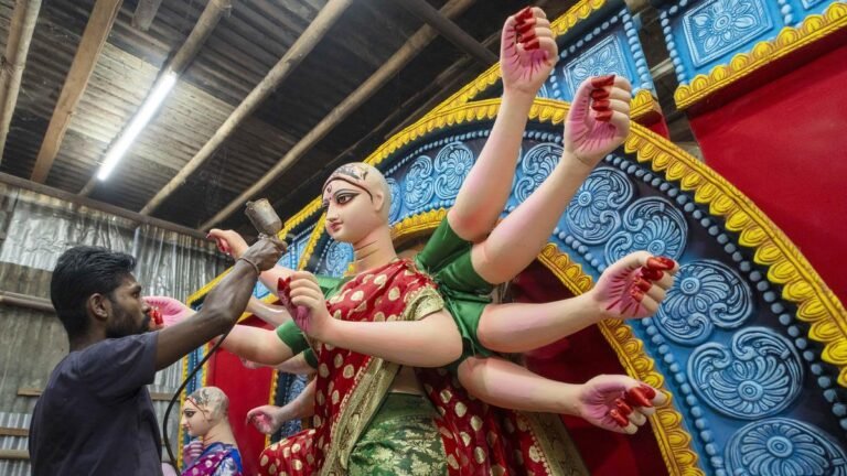 A billboard with Goddess Durga next to a pot of biryani sparkles in the city of Hooghly